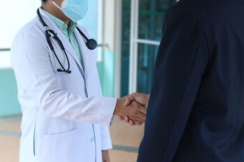 Medic care dă mâna cu un pacient